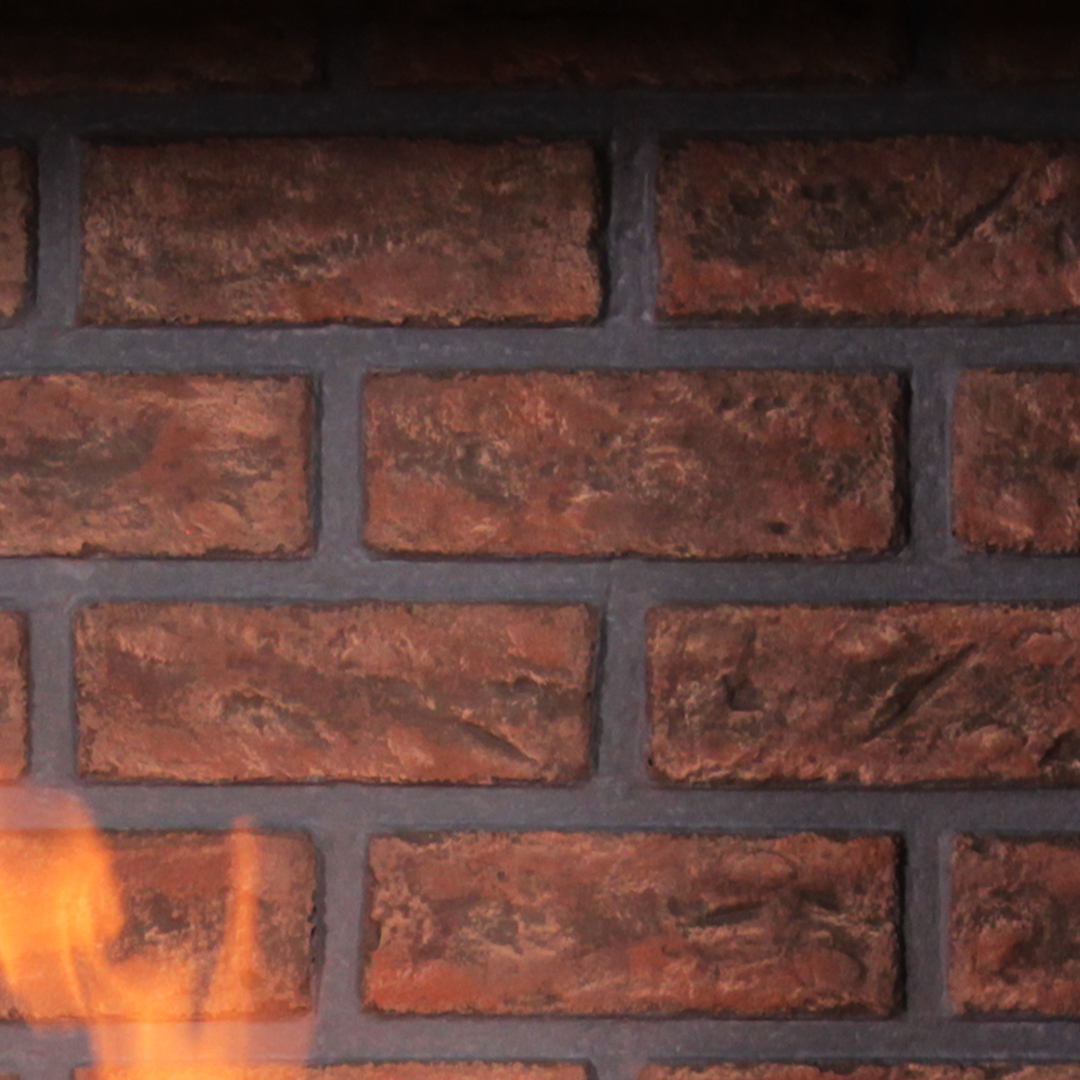 Brick wall with a small orange flame peeking in from the bottom left corner.